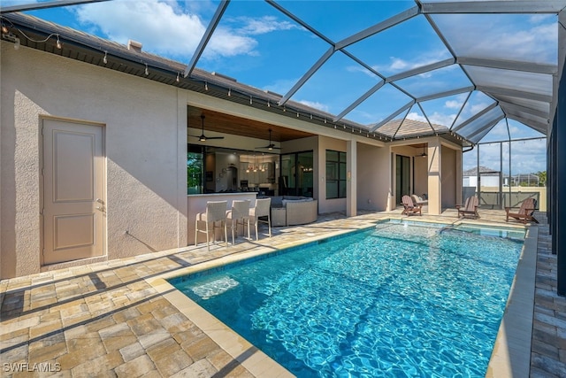 view of pool featuring ceiling fan, an outdoor bar, a lanai, and a patio area