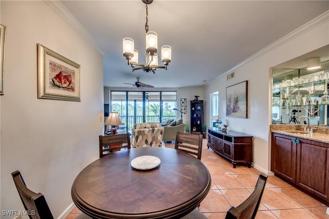 tiled dining room with ceiling fan with notable chandelier, ornamental molding, and sink