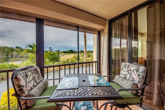 sunroom / solarium featuring a water view