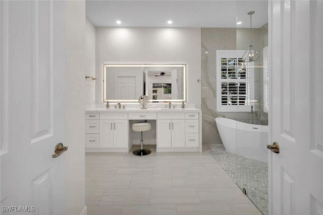 bathroom with a washtub, vanity, tile patterned floors, and ceiling fan