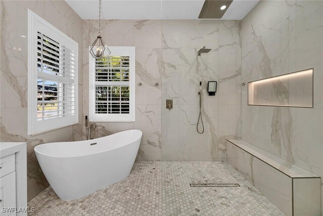 bathroom with tile patterned floors, vanity, shower with separate bathtub, and a chandelier