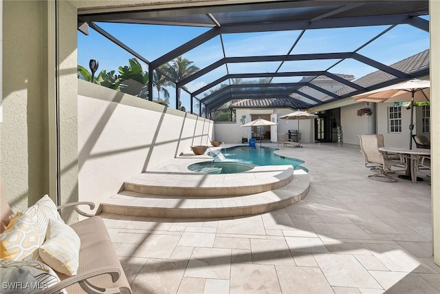 view of pool with pool water feature, a patio, a lanai, and an in ground hot tub