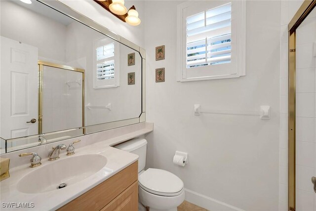 bathroom featuring vanity, toilet, and walk in shower