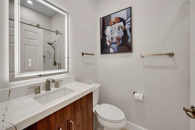 bathroom with vanity, toilet, and a tile shower