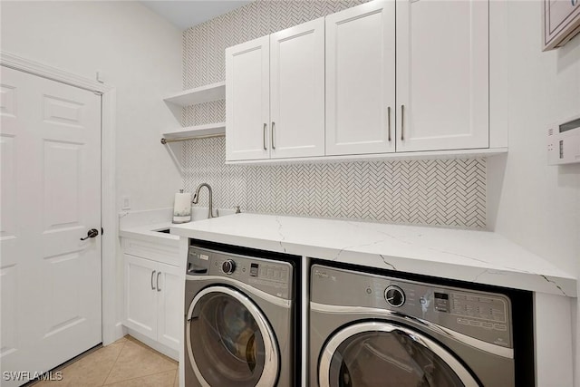 laundry area featuring sink, cabinets, independent washer and dryer, and light tile patterned flooring