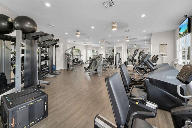 workout area with ceiling fan and light hardwood / wood-style floors