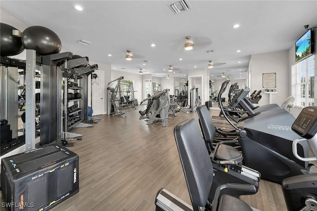 gym with light hardwood / wood-style floors and ceiling fan