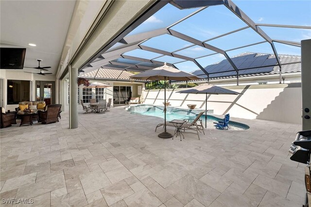 view of pool with glass enclosure, an outdoor hangout area, and a patio