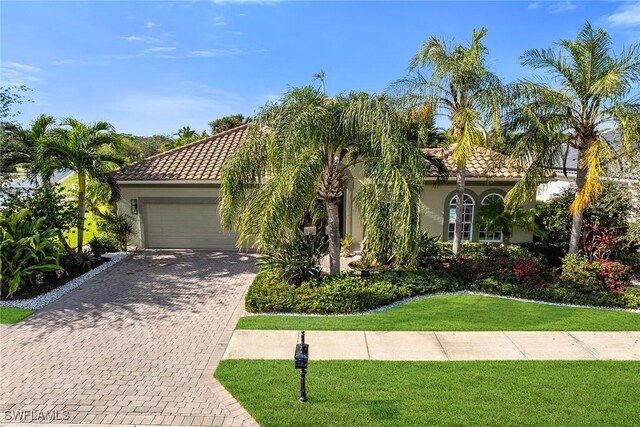 mediterranean / spanish house with a front lawn and a garage