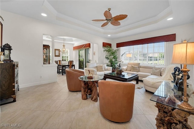 living room featuring crown molding, light tile patterned floors, ceiling fan, and a tray ceiling