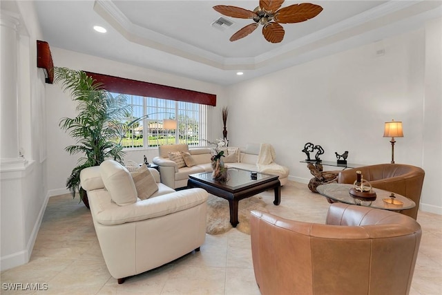 tiled living room with ceiling fan, ornamental molding, and a raised ceiling