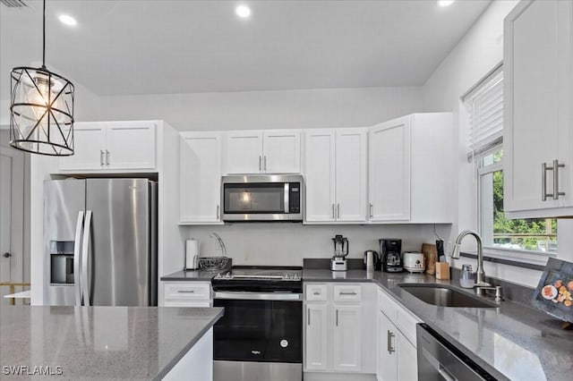 kitchen featuring dark stone countertops, white cabinetry, sink, and appliances with stainless steel finishes