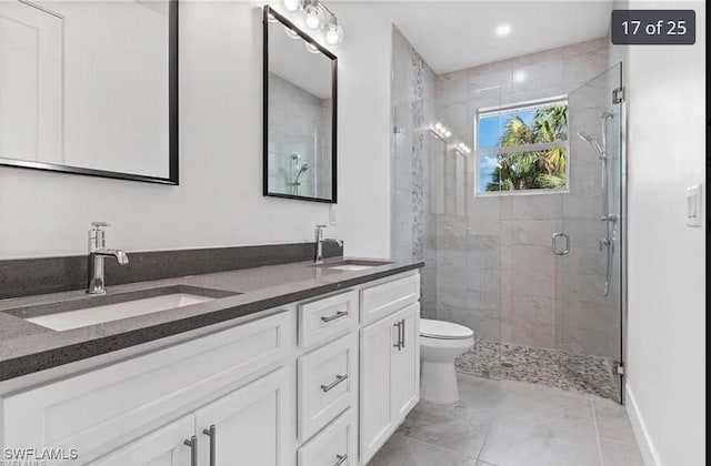 bathroom featuring tile patterned floors, vanity, toilet, and walk in shower