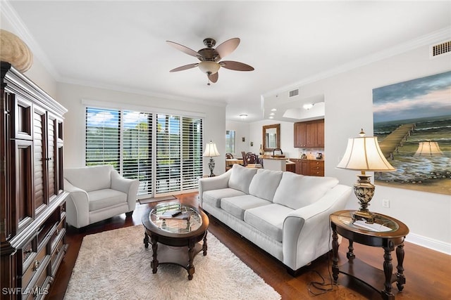 living room featuring ceiling fan, dark hardwood / wood-style flooring, and crown molding