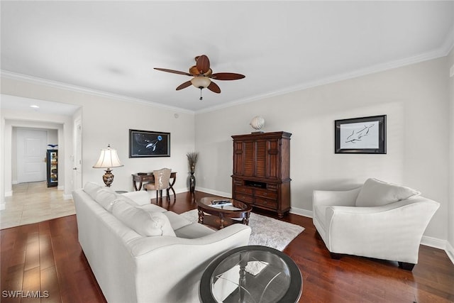 living room with dark hardwood / wood-style flooring, ceiling fan, and crown molding