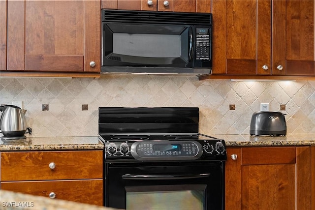 kitchen featuring black appliances, stone countertops, and backsplash