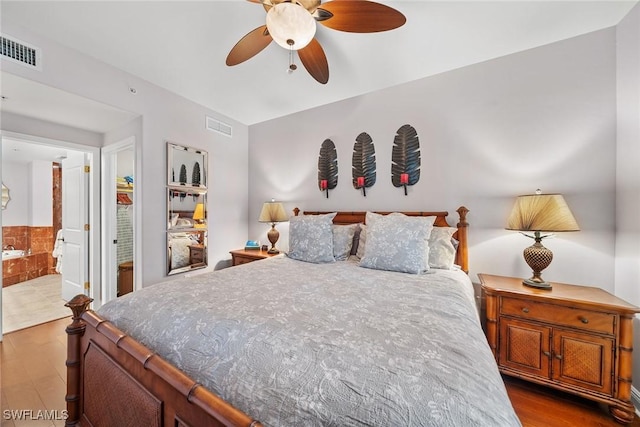 bedroom with ensuite bathroom, ceiling fan, and wood-type flooring