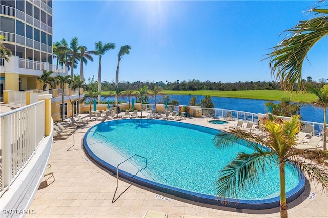 view of pool with a patio area and a water view