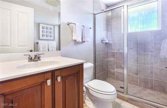 bathroom with vanity, an enclosed shower, and toilet