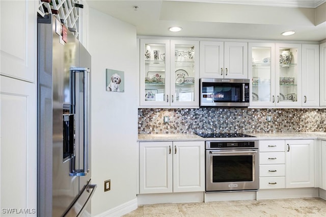 kitchen featuring decorative backsplash, white cabinets, and stainless steel appliances