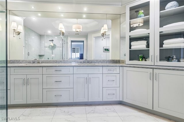 bathroom with vanity, crown molding, and a shower with shower door