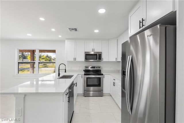 kitchen featuring white cabinets, light stone counters, sink, and appliances with stainless steel finishes