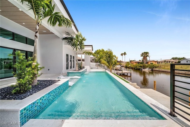 view of swimming pool featuring a patio area, pool water feature, and a water view