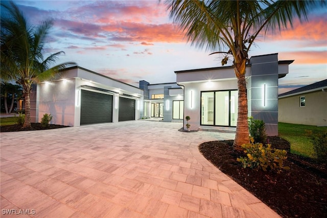 back house at dusk with a garage