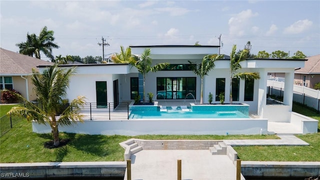 back of house featuring a yard, pool water feature, a fenced in pool, and a patio