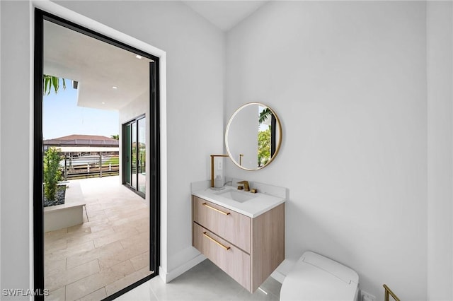 bathroom featuring plenty of natural light, toilet, and vanity