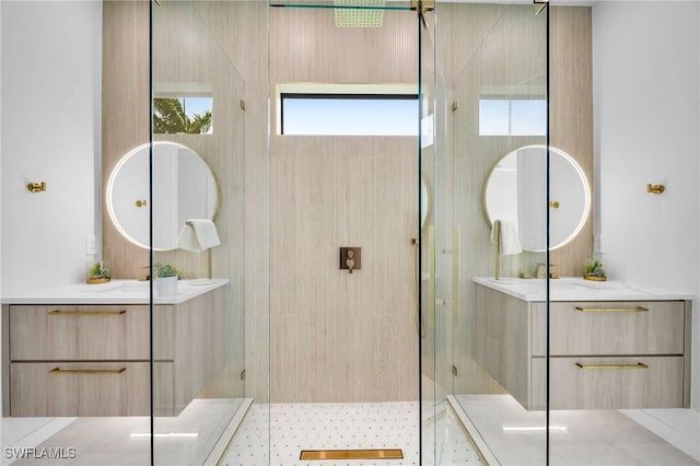 bathroom with a tile shower and vanity