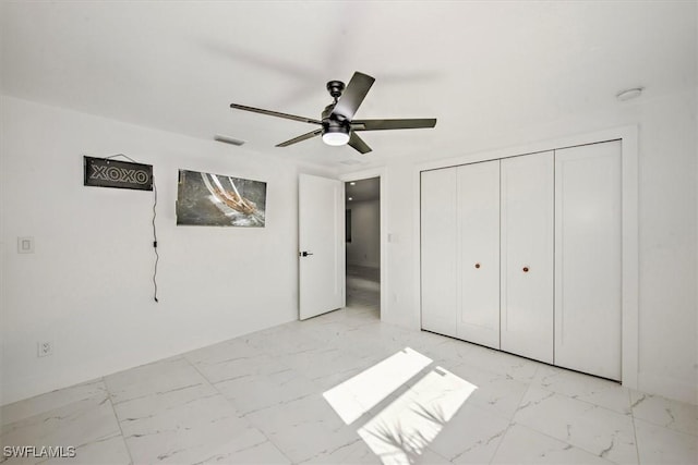 unfurnished bedroom with ceiling fan and a closet