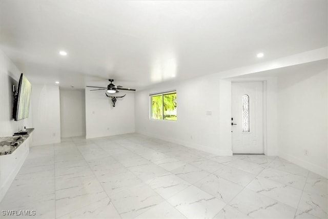 unfurnished living room with ceiling fan