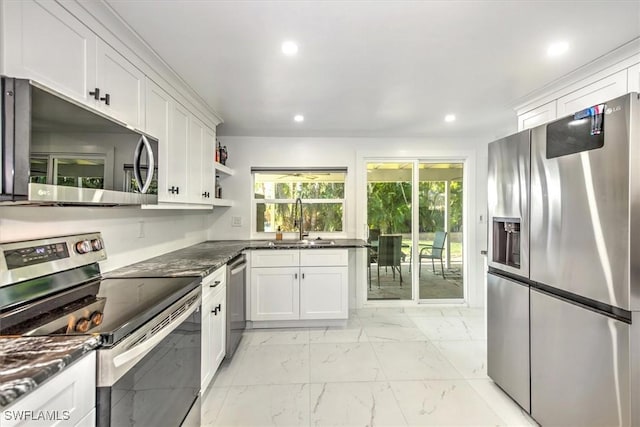 kitchen featuring dark stone countertops, white cabinetry, sink, and appliances with stainless steel finishes