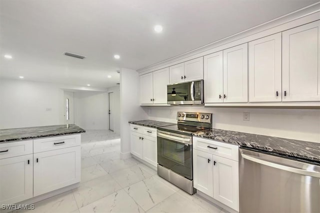 kitchen featuring dark stone counters, white cabinetry, and stainless steel appliances