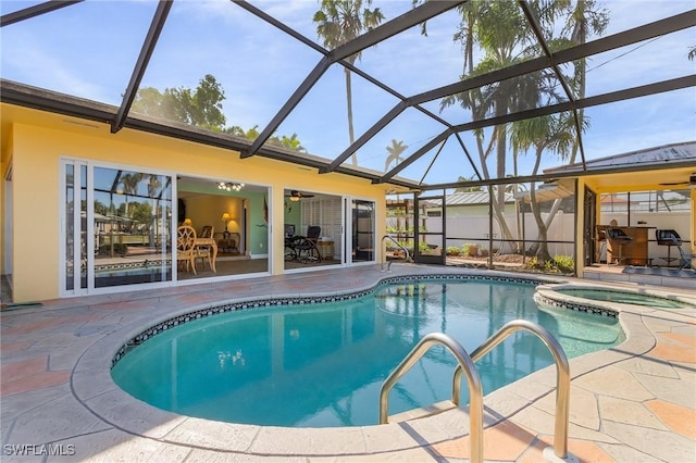 view of pool featuring glass enclosure, a pool with connected hot tub, and a patio area