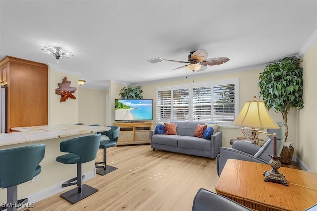 living room featuring ceiling fan, light wood-type flooring, and crown molding