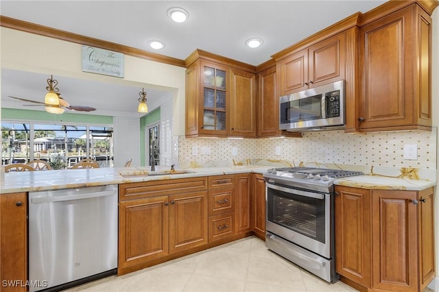 kitchen with ceiling fan, sink, tasteful backsplash, kitchen peninsula, and appliances with stainless steel finishes