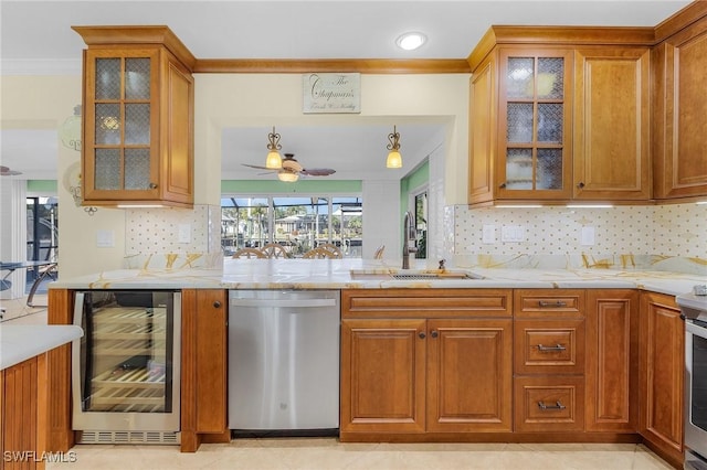 kitchen featuring light stone countertops, appliances with stainless steel finishes, ceiling fan, sink, and wine cooler