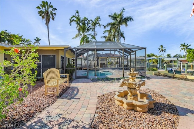 view of swimming pool featuring glass enclosure