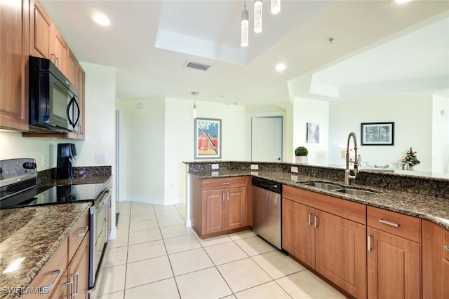 kitchen with sink, a tray ceiling, hanging light fixtures, and black appliances