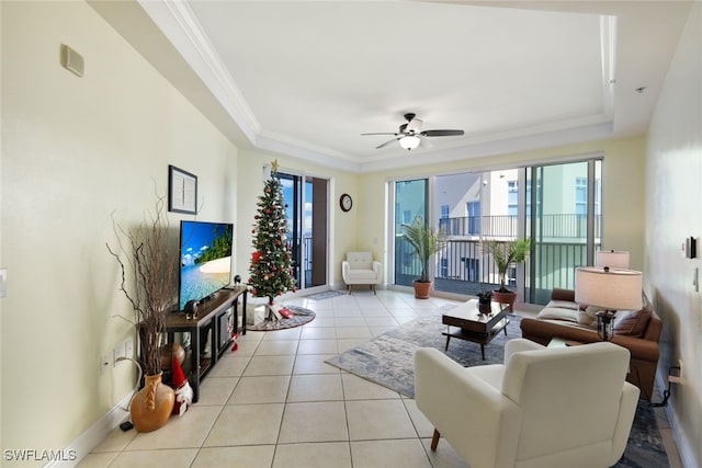 tiled living room featuring a tray ceiling, ceiling fan, and crown molding