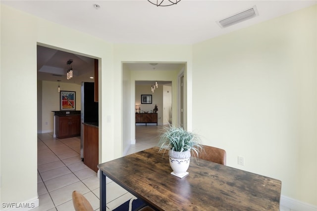 tiled dining room featuring a chandelier