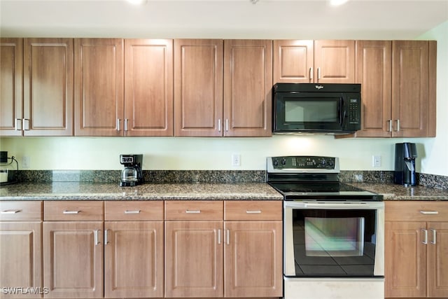 kitchen featuring stainless steel electric range oven and dark stone counters