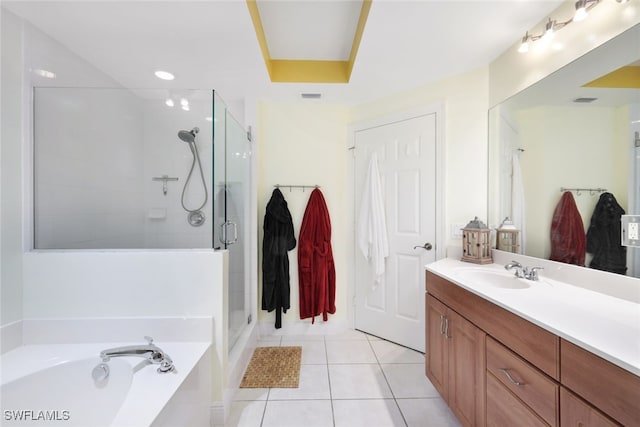 bathroom with a tray ceiling, tile patterned flooring, vanity, and independent shower and bath