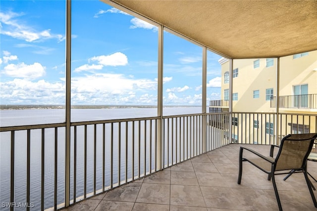 unfurnished sunroom featuring a water view and a wealth of natural light