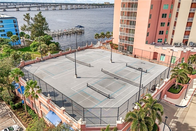 view of tennis court featuring a water view