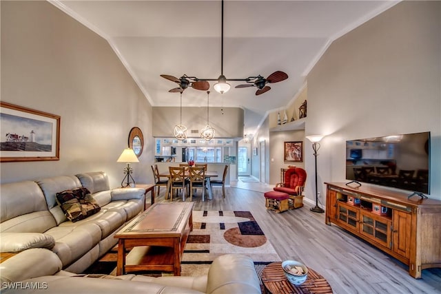 living room featuring crown molding, light hardwood / wood-style flooring, ceiling fan, and vaulted ceiling