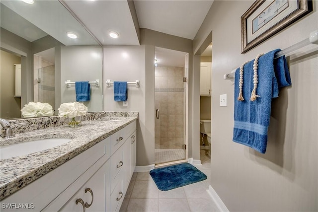 bathroom with tile patterned flooring, vanity, a shower with door, and toilet