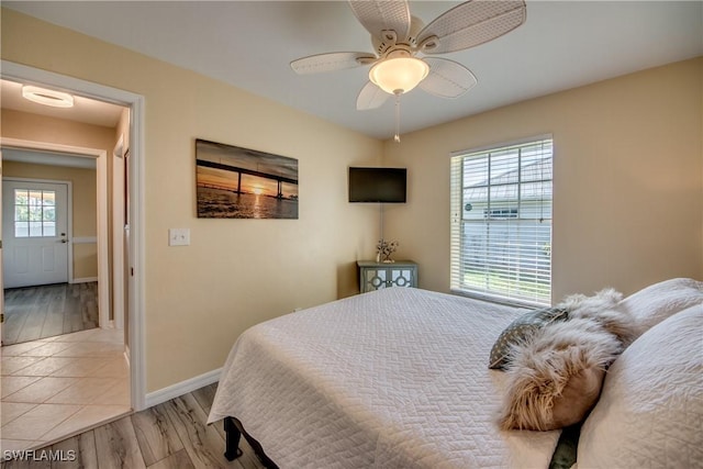 bedroom featuring ceiling fan, light wood-type flooring, and multiple windows